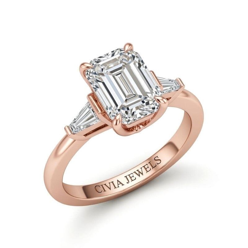 Rose Gold Emerald Cut Three Stone Engagement Ring With Tapered Baguette Side Diamonds And Classic Four Prong Setting