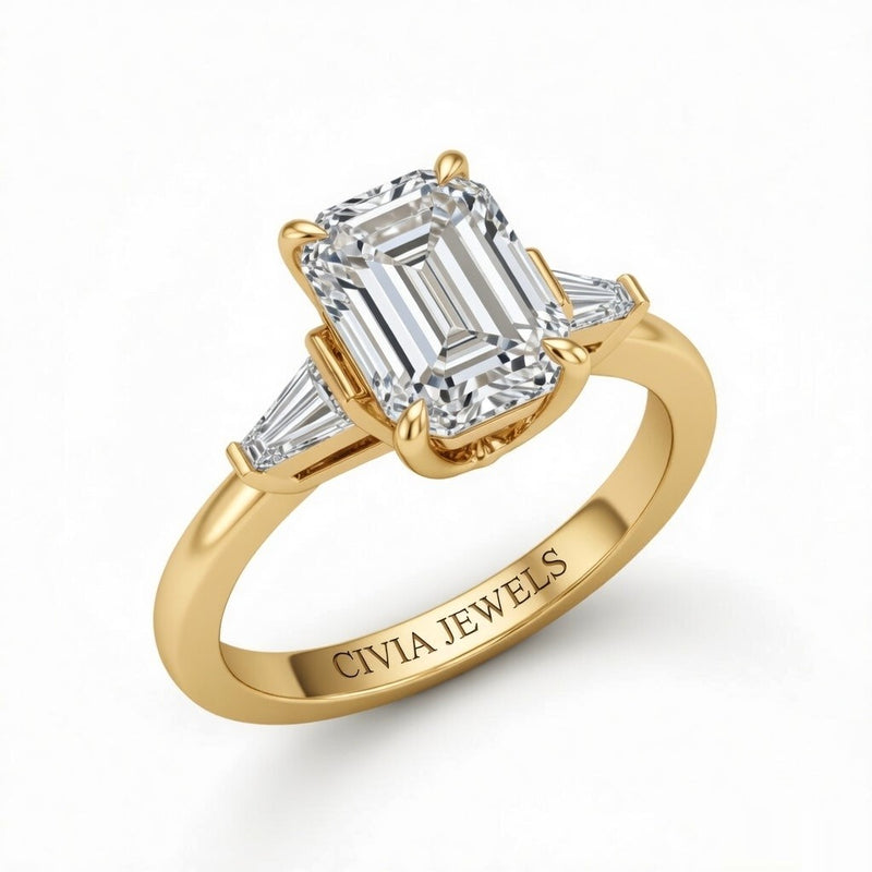 Yellow Gold Emerald Cut Three Stone Engagement Ring With Tapered Baguette Side Diamonds And Classic Four Prong Setting