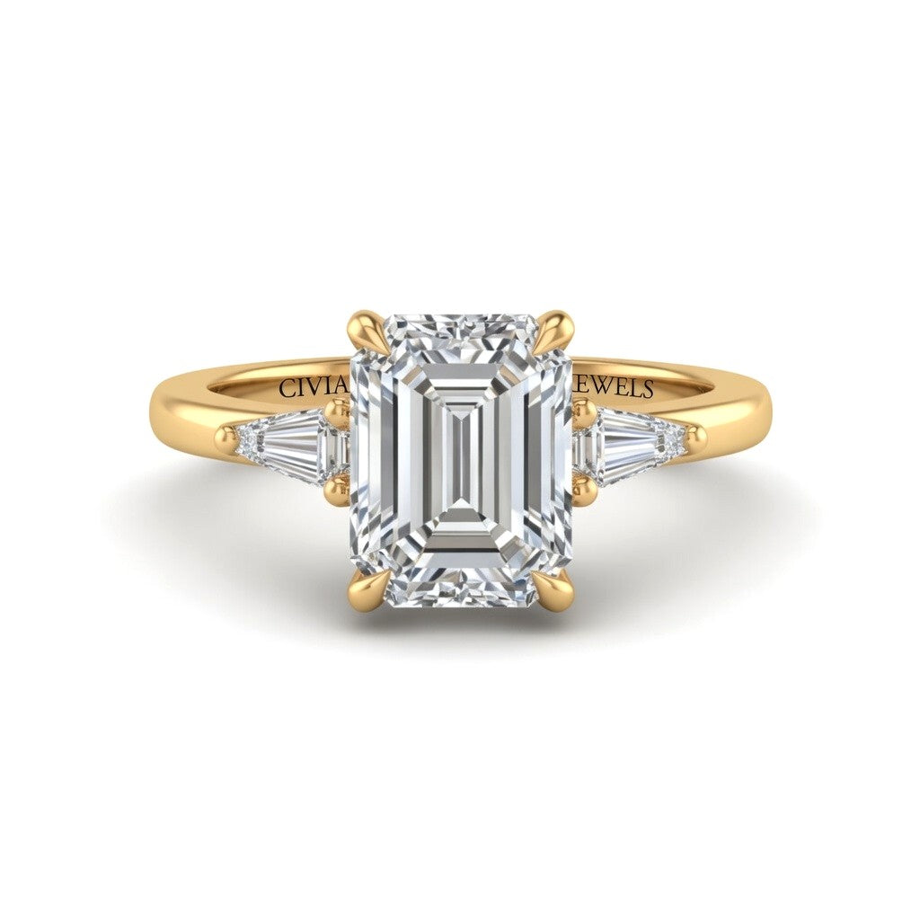 Yellow Gold Emerald Cut Three Stone Engagement Ring With Tapered Baguette Side Diamonds And Classic Four Prong Setting