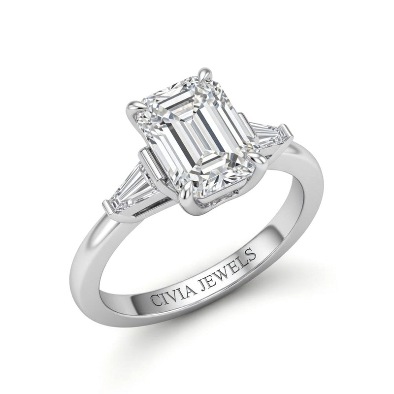 Silver Emerald Cut Three Stone Engagement Ring With Tapered Baguette Side Diamonds And Classic Four Prong Setting