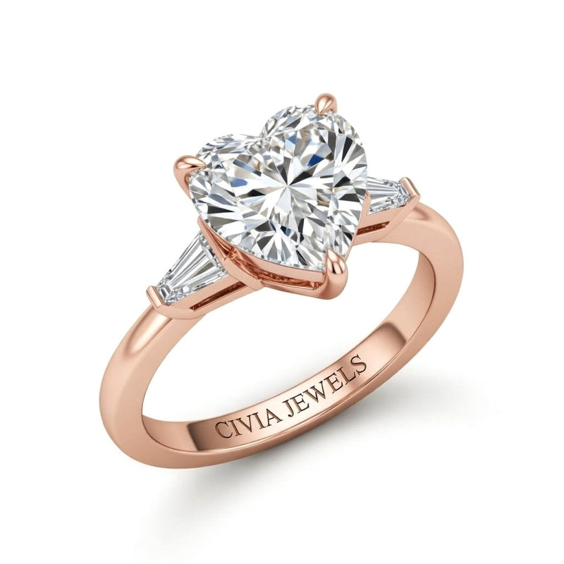 Rose Gold Heart Cut Three Stone Engagement Ring With Tapered Baguette Side Diamonds And Classic Four Prong Setting