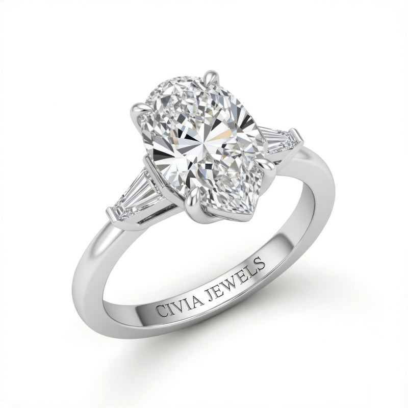 White Gold Pear Cut Three Stone Engagement Ring With Tapered Baguette Side Diamonds And Classic Four Prong Setting