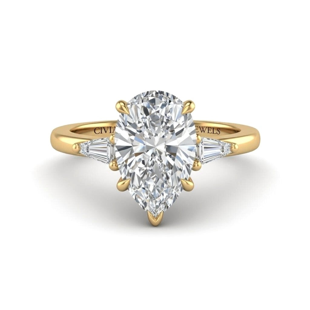 Yellow Gold Pear Cut Three Stone Engagement Ring With Tapered Baguette Side Diamonds And Classic Four Prong Setting