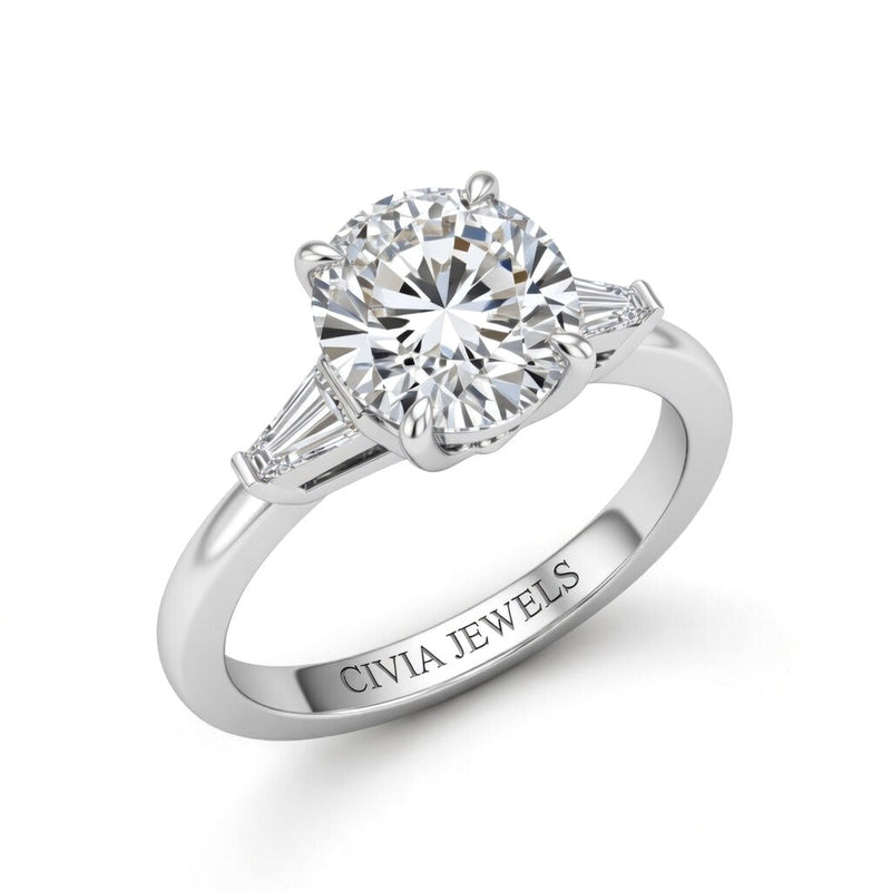 Silver Round Cut Three Stone Engagement Ring With Tapered Baguette Side Diamonds And Classic Four Prong Setting