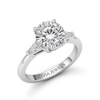 Silver Round Cut Three Stone Engagement Ring With Tapered Baguette Side Diamonds And Classic Four Prong Setting